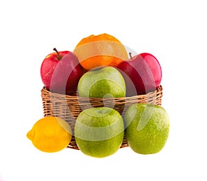 Red and green apples and lemons in a wooden basket,