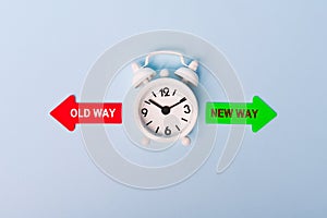 Red and green arrows - direction indicator - choice of old or new way. Concept of choice. Two Arrows and White alarm clock on blue