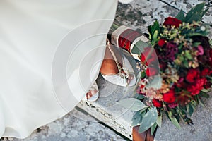 Red-Green bridal bouquet at the feet of the bride