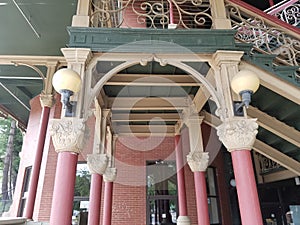 Red and green building with columns and stairs