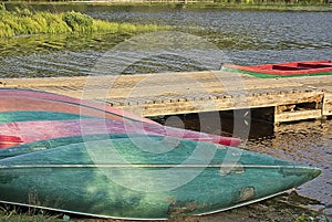 red and green canoes deposited on the shore of the lake, mauricie