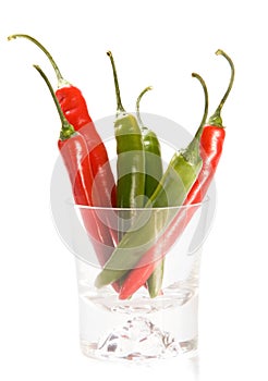 Red and green chilly peppers in glass