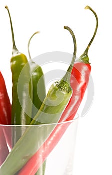 Red and green chilly peppers in glass