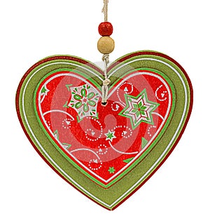 Red and green Christmas decorative wooden pendant in heart form with snowflakes and stars isolated on white