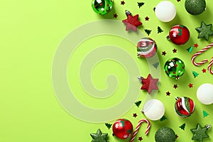 Red and green Christmas ornaments on pastel green background. Xmas greeting card template, Happy New Year banner design. Flat lay