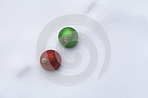 Red and green Christmas ornaments in snow