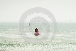 Red and green colored ship buoys on the water surface of a ship passage in the western part of the world