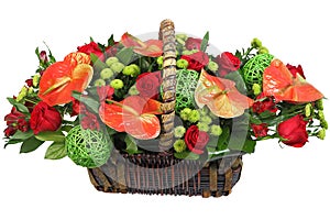 Red-and-green floral arrangement in a wicker basket.