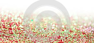Red and green glitter shine dots confetti. Abstract light blur blink sparkle defocus backgound