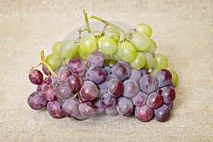 Red and green grapes on canvas background