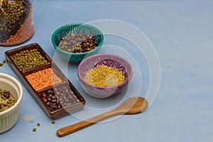 Red and green lentils and beans in a scrambler, bowls with bulgur and beans,close-up, blue background