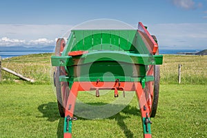 A red and green painted small horse pulled wagon