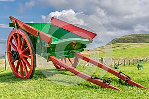 A red and green painted small horse pulled wagon