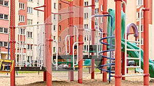 Red green playground attractions in yard against building