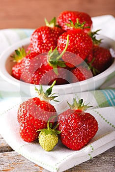 Red and green strawberries on towel in front of bowl