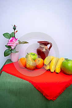 Red and green tablecloth with pears, bananas, oranges and fresh green apples