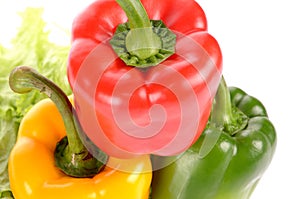 Red Green and Yellow peppers on salad leaf isolated on white background