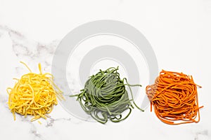 Red, green and yellow raw spaghettis