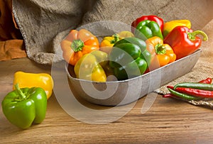 Red, green and yellow sweet bell peppers on table,
