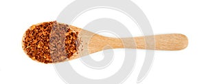 Red ground paprika powder or dry chili pepper with wooden spoon isolated on white background