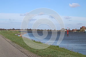 Red guiding post in the river Hollandsche IJssel to mark the safe waterway in the water.