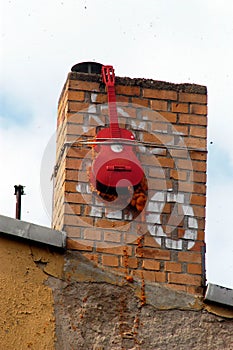 Red guitar on a chimney