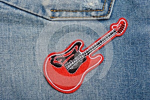 Red guitar patch on jeans