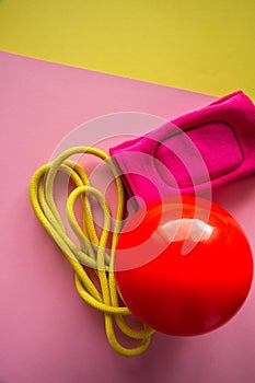 Red gymnastic ball, kneepads and skipping rope on a duotone back