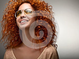 Red Hair. Beautiful Woman with Curly Long Hair and Sunglases