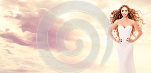 Red Hair Bride in White Dress over Sky Sunset. Beauty Model with Long Curly Hairstyle Art Portrait. Fantasy Red Head Woman