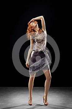 Red hair model dancing in fashion dress