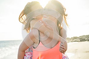 Red hair mother and daughter having fun on the beach - Mother enjoying time with her kid - Family lifestyle and love concept - Sun