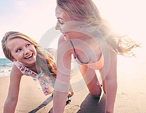 Red hair mother and daughter having fun on tropical beach - Mum playing with her kid in holiday vacation - Family lifestyle and