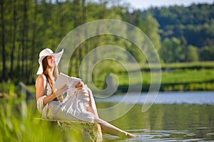 Red hair romantic woman relax by lake with book