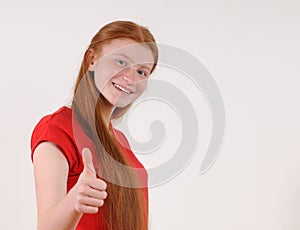 Red hair tennager girl in a red shirt showing a thumbs-up