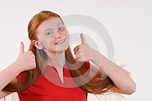 Red hair tennager girl in a red shirt showing a thumbs-up on both hands