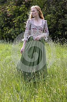 Red-haired 18th century woman wandering in the wilderness