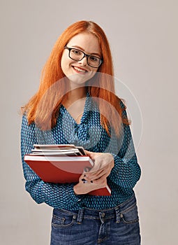 Red-haired beautiful girl in glasses. student is ready to study