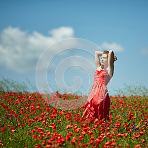 Red haired beautiful girl in poppy field