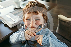 Red haired boy with forks playing the ape