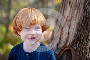 Red-haired boy smiles funny