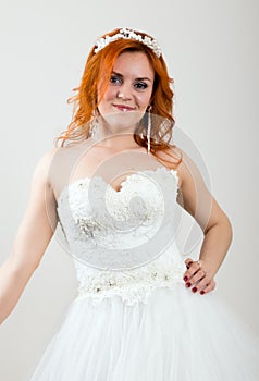 Red-haired bride in a wedding dress, bright unusual appearance. Beautiful wedding hairstyle and bright make-up
