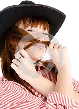 Red haired cowgirl in hat grimacing