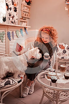 Red-haired curly woman celebrating birthday of her dogs