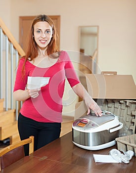 Red haired female unpacking and reading user manual for new croc