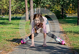 Red-haired girl with braids riding on rollers and falls in the p