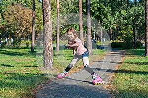 Red-haired girl with braids skates on pink rollers and falls in