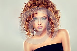 Red haired girl with curly hairstyle. photo