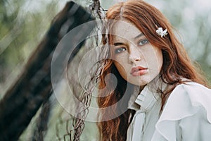 Red-haired girl with freckles in cherry blossom