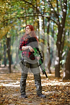 Red-haired girl holds a rifle in his hands